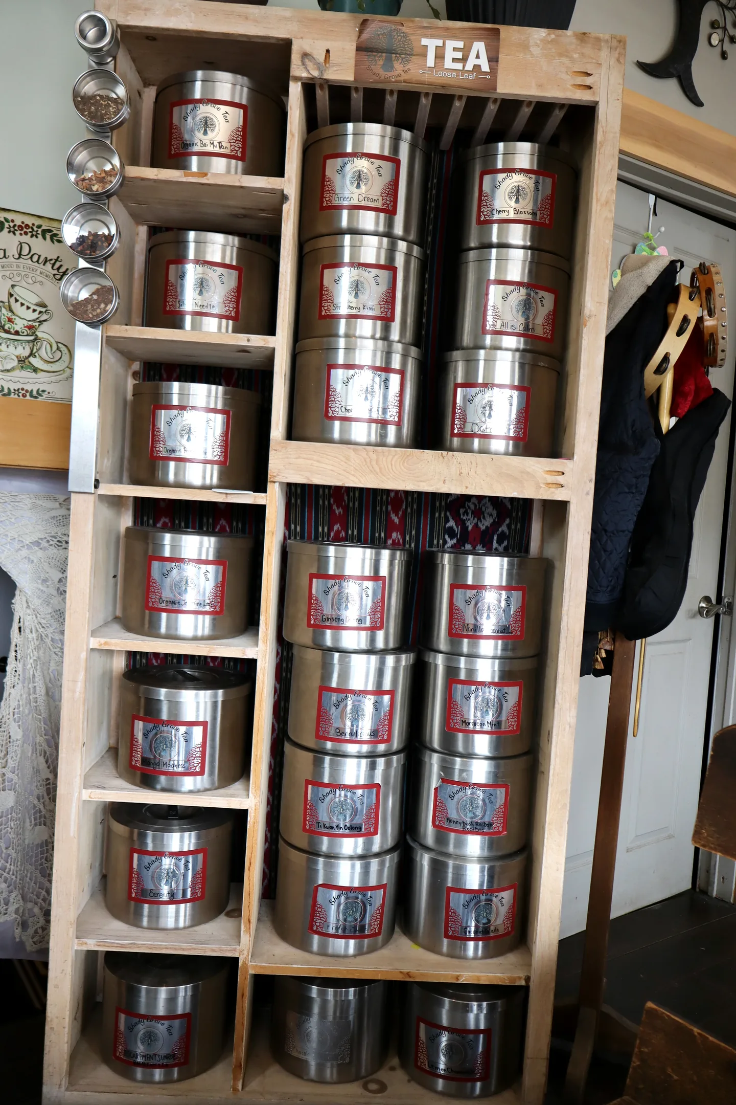 Shelves filled with loose-leaf tea tins inside Lukaya Cafe